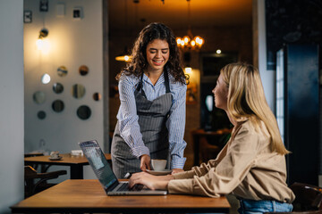 Polite waitress serves coffee to a businesswoman