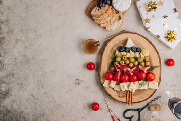 Christmas snack tree on rustic wooden board over stone background. Cheese plate. Christmas food concept.