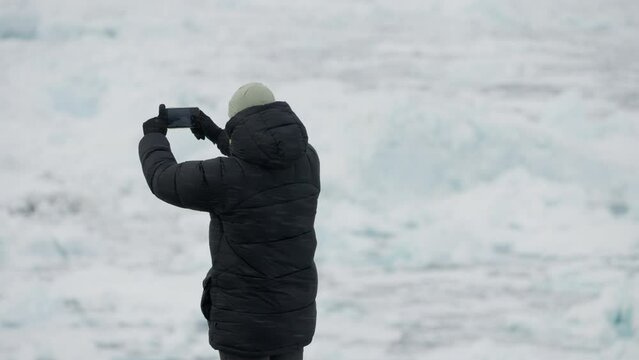 Medium Wide-Shot Of A Man Focusing For A Photo Of Glaciers