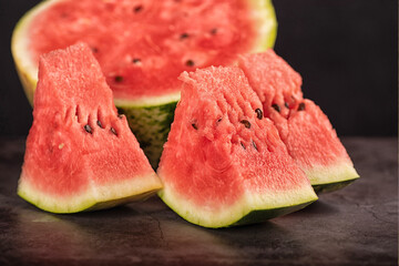 Closeup of watermelon slices and halved watermelon on kitchen counter