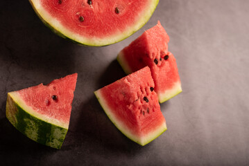 Top view of watermelon slices and halved watermelon on kitchen counter