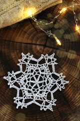 Crochet white snowflake on wooden backgraund
