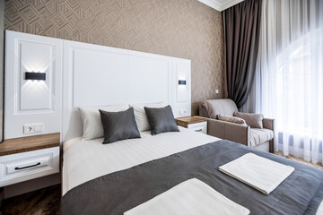 Modern Bedroom. The headboard of a large white double bed. Brown and white pillows.