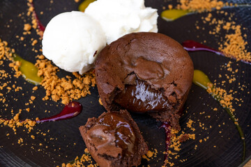 Plate of delicious warm dessert chocolate cake Fondant served with ice-cream balls. Lava cake on a decorated plate.