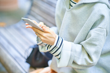 スマートフォンの画面を見る女性