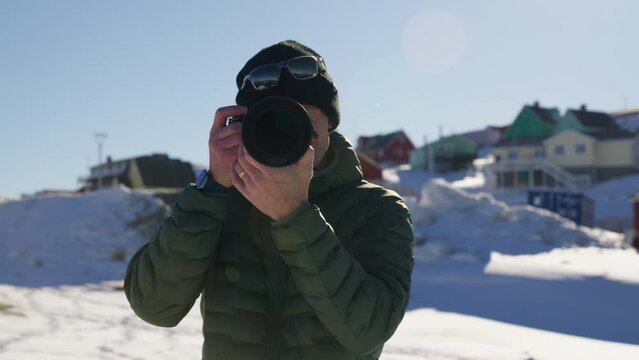 Close-up Shot Of A Man Using His Camera In A Winter Town