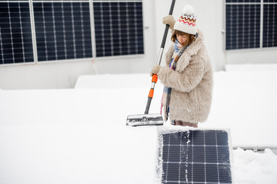 Woman cleans solar panels from snow