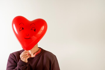 man with two heart-shaped balloons with one-sided drawing, space for writing, gift or greeting card for valentine's day