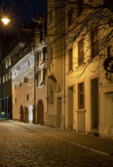 Fototapeta na wymiar Old medieval cobbled street in the historical center of Riga at night.