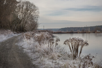 Snow-covered winter trees on the river bank.