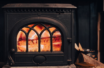 A cozy home black metal stove with a fire. fire in the oven