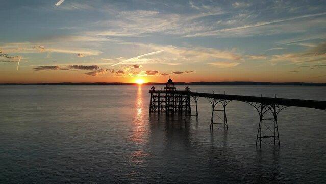 Gorgeous aerial view of the Clevedon Pier at sunset with the sun just above the horizon