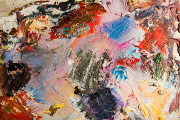 Used artist's palette with mixed colors, oil paints, closeup as art background, horizontal, nobody
