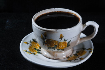 a cup of brewed Javanese black coffee isolated on a black background