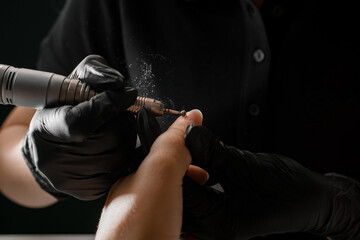 Close-up of hands of manicurist in gloves accurate removing cuticle on woman hand with professional...