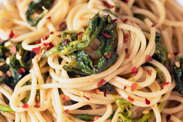 Piatto di deliziosi spaghetti piccanti con cime di rapa, olio di oliva e peperoncino, cibo italiano 