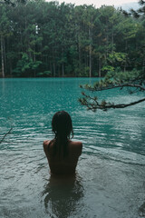 Wild swimming in a mountain lake. A beautiful girl swims in a mountain lake.