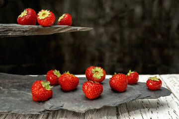 Ripe strawberries on a slate stone on a dark background. copy space...