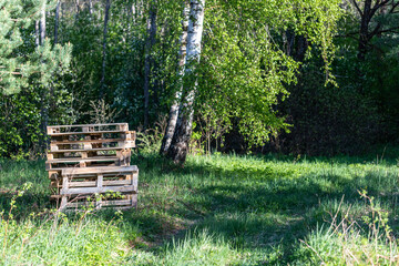 wooden palettes in field near green forest	