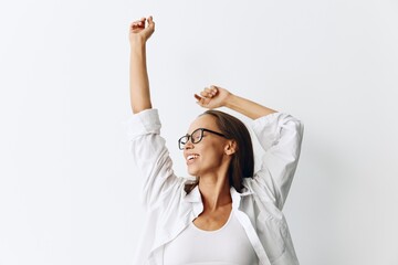 Happy woman having fun at home in a white top and white shirt with glasses against a white wall, lifestyle
