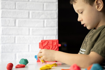 the child sculpts from bright plasticine, children's hands, close-up, the development of fine motor skills 