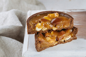 Mini chocolate cakes on wooden background. Cashew nut filling, almonds, peanuts.