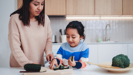 Happy Asian mother and son cooking inside home kitchen - Focus on boy face