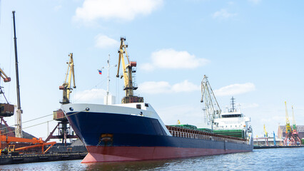 Fototapeta premium Vessel on which coal is loaded at the seaport. Port cranes for loading coal onto ship, Kaliningrad, Russia