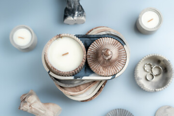 candles and handmade decor on a blue background, business for moms on maternity leave, space for text, top view