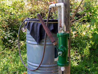 A rural watering system made with a manual pump and a metal barrel, in a farm near the colonial town of Villa de Leyva in central Colombia.