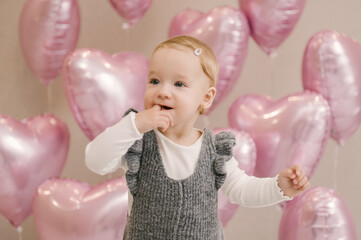 Obraz na płótnie Canvas Cute little girl, 1st birthday, baby with helium balloons pink hearts