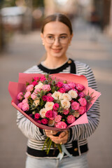 Fototapeta premium selective focus on bouquet with roses and thistles in hands of woman