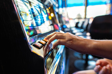 Gambler Pressing Slot Machine Button in the Casino