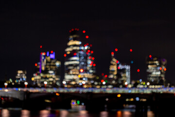 Blurred image of Nightlife in London, busy traffic on the bridge over the river Thames near the business district with glittering skyscrapers