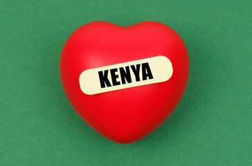 On a green surface lies a red heart with the inscription - Kenya
