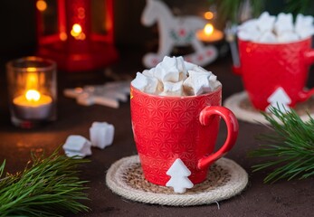 Festive composition, cocoa with star-shaped marshmallows in a red cup on a brown concrete...
