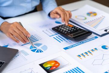 Asian business ideas are thinking and calculating with a calculator. front view of hand pointing to business data chart to calculate analysis Company financial processing.