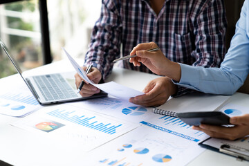 Asian business ideas are thinking and calculating with a calculator. front view of hand pointing to business data chart to calculate analysis Company financial processing.