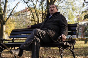 Fototapeta premium Lonely senior man sitting on bench