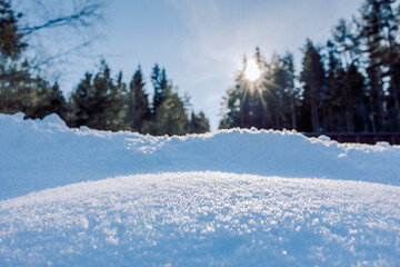 Winter Merry christmas and happy new year background. Beautiful snowdrifts with light, snow flakes, forest and sun with rays. Copy space, banner. High quality photo