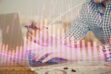 Multi exposure of forex graph with man working on computer on background. Concept of market analysis.