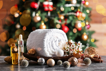 Christmas composition with towel and essential oils for spa treatment on table