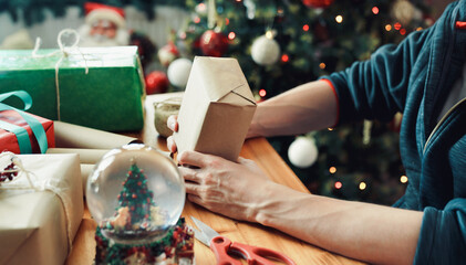 Man wrapping Christmas gift with craft paper. Christmas or New year DIY packing Concept. 