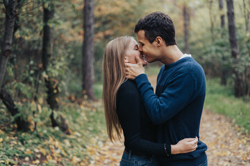 Fototapeta premium Romantic young couple kissing in a forest