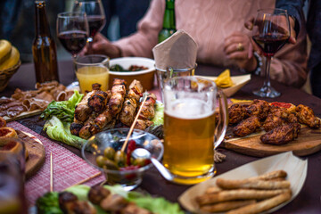 Bbq dinner with meat, salads, cooked vegetables and drinks.