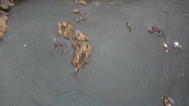 Aerial view of small stone islands in the ocean and green landscape, Ireland