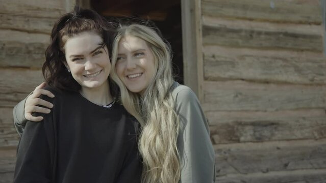 Portrait of smiling teenage girls hugging in ghost town / Grafton, Utah, United States