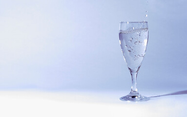 a glass of water in front of a white background and bubbles in the water