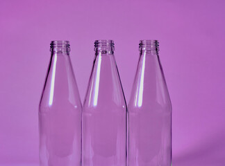 colored empty glass bottles standing isolated in front of a colorful background. Recycling and...