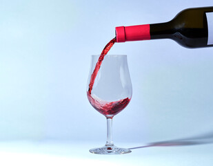 put wine in a wine glass in front of a white background. 